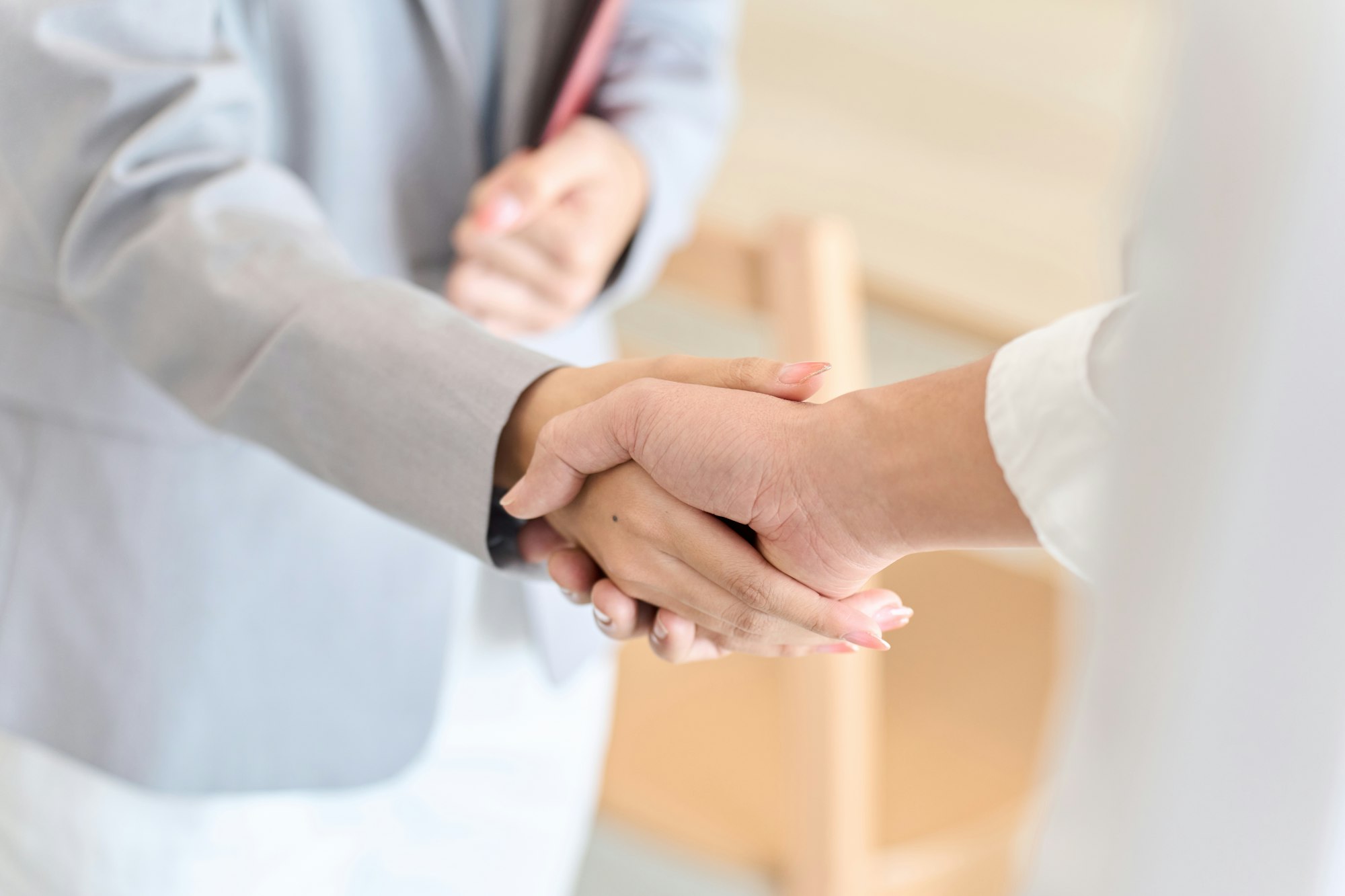 A man and a woman shake hands after closing a real estate deal